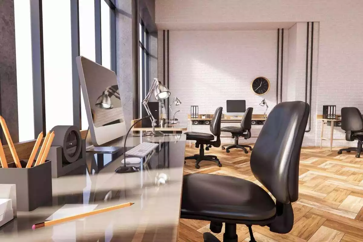 Imagen de una oficina con varias sillas y ordenadores